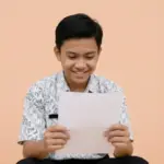 Seorang Siswa sedang melihat sertifikat hasil TKA