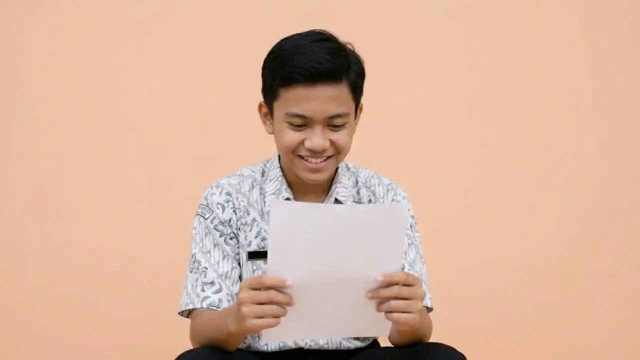Seorang Siswa sedang melihat sertifikat hasil TKA